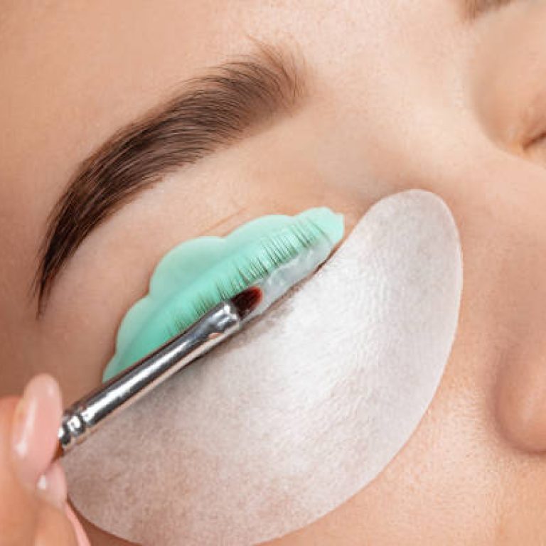 Make-up artist makes the procedure of lamination and dyeing of eyelashes to a beautiful woman in a beauty salon. Eyelash extensions. Eyelash lifting