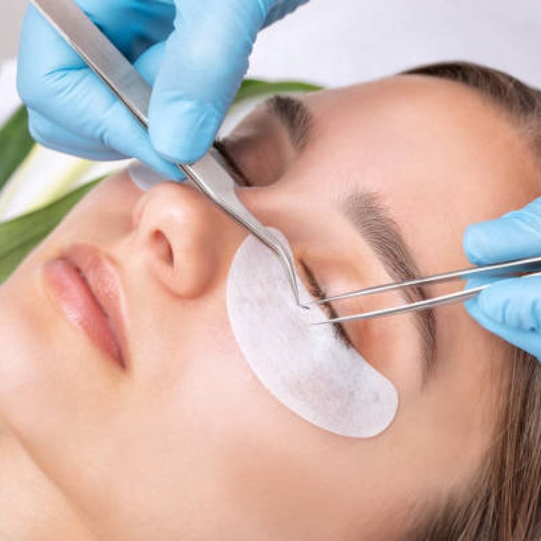 Beautiful Woman with long eyelashes in a beauty salon. Eyelash extension procedure. Lashes close up