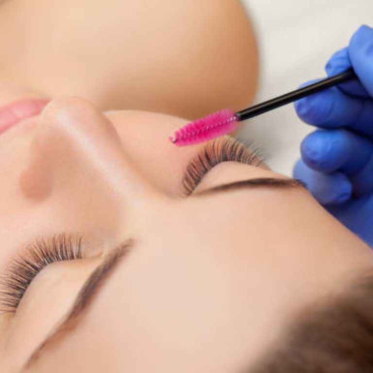 Eyelash extension procedure close up. Beautiful woman with long eyelashes in a beauty salon. Makeup concept